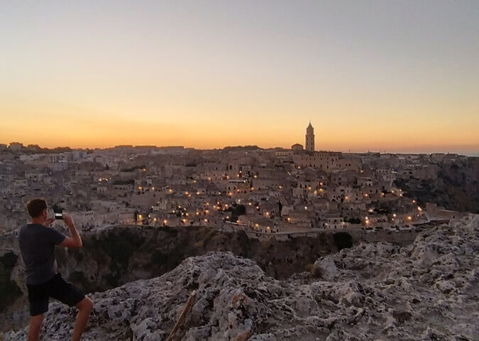 Un turista scatta una fotografia in un momento davvero mozzafiato ai Sassi di Matera. Il momento è magico.